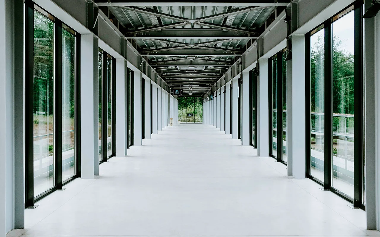 crisvisa-control-solar-SGG-COOL-LITE-SKN-white-hallway-with-glass-doors-and-metal-ceiling-in-modern-building crisvisa-control-solar-SGG-COOL-LITE-SKN-white-hallway-with-glass-doors-and-metal-ceiling-in-modern-building